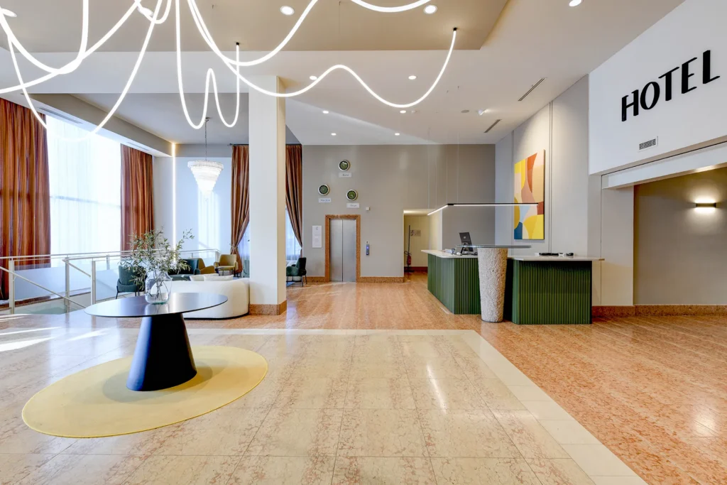 Hall ampia e luminosa con reception e area relax dell’Hotel Garda di Affi vicino al Lago di Garda